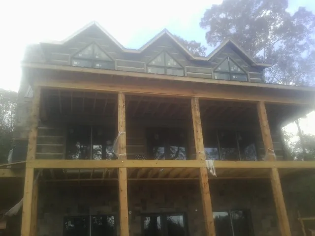 Dormers and porch framing on a large log home under construction — Roof Coating work by our crew in Beersheba Springs