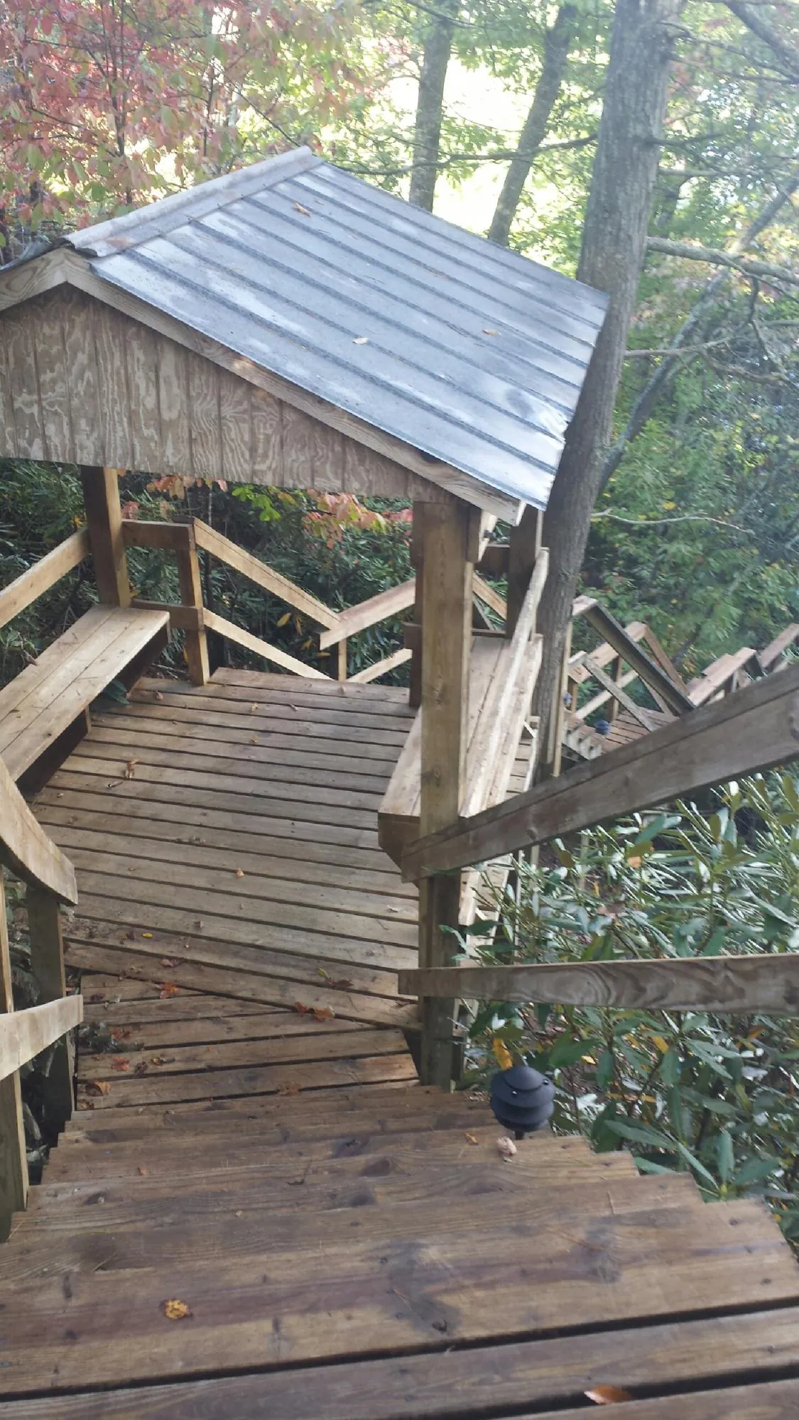 Metal roofed shelter over wooden steps on a wooded walkway — Skylight Repair & Installation work by our crew in Beersheba Springs